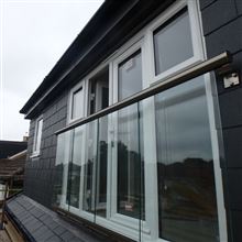 Dormer loft conversion in West Ealing W13 by Ash Island Lofts with glass balcony