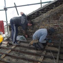Anthony and Brian cutting pockets in the party wall for the steel bearer plates